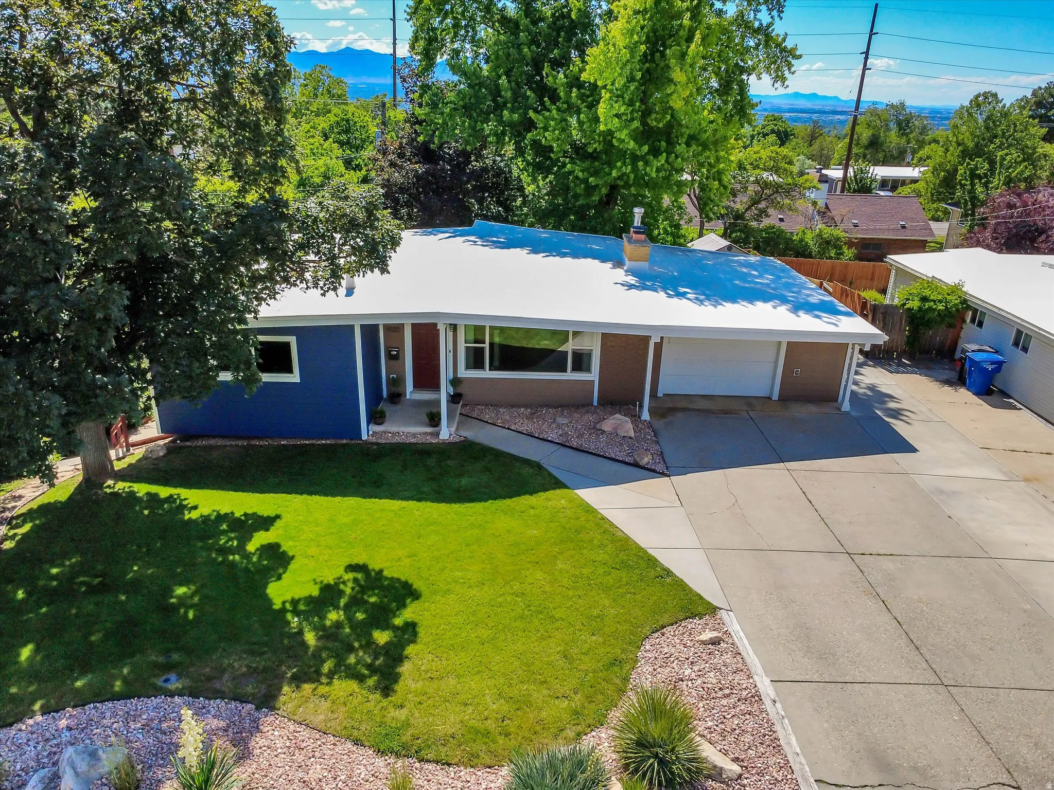 Contemporary ranch-style residence featuring a prominent white roof and a two-tone exterior