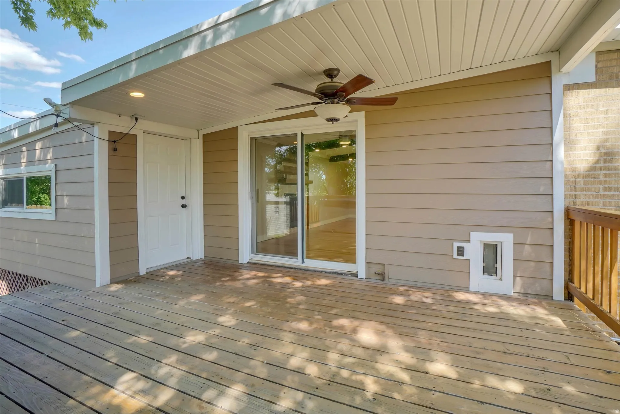 Expansive wooden deck with an overhead ceiling fan