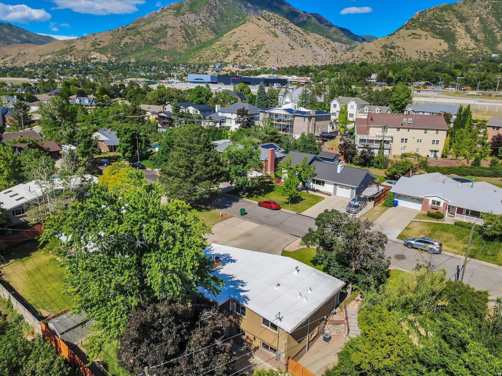 Residential neighborhood featuring mountain backdrops, mature trees, and established properties