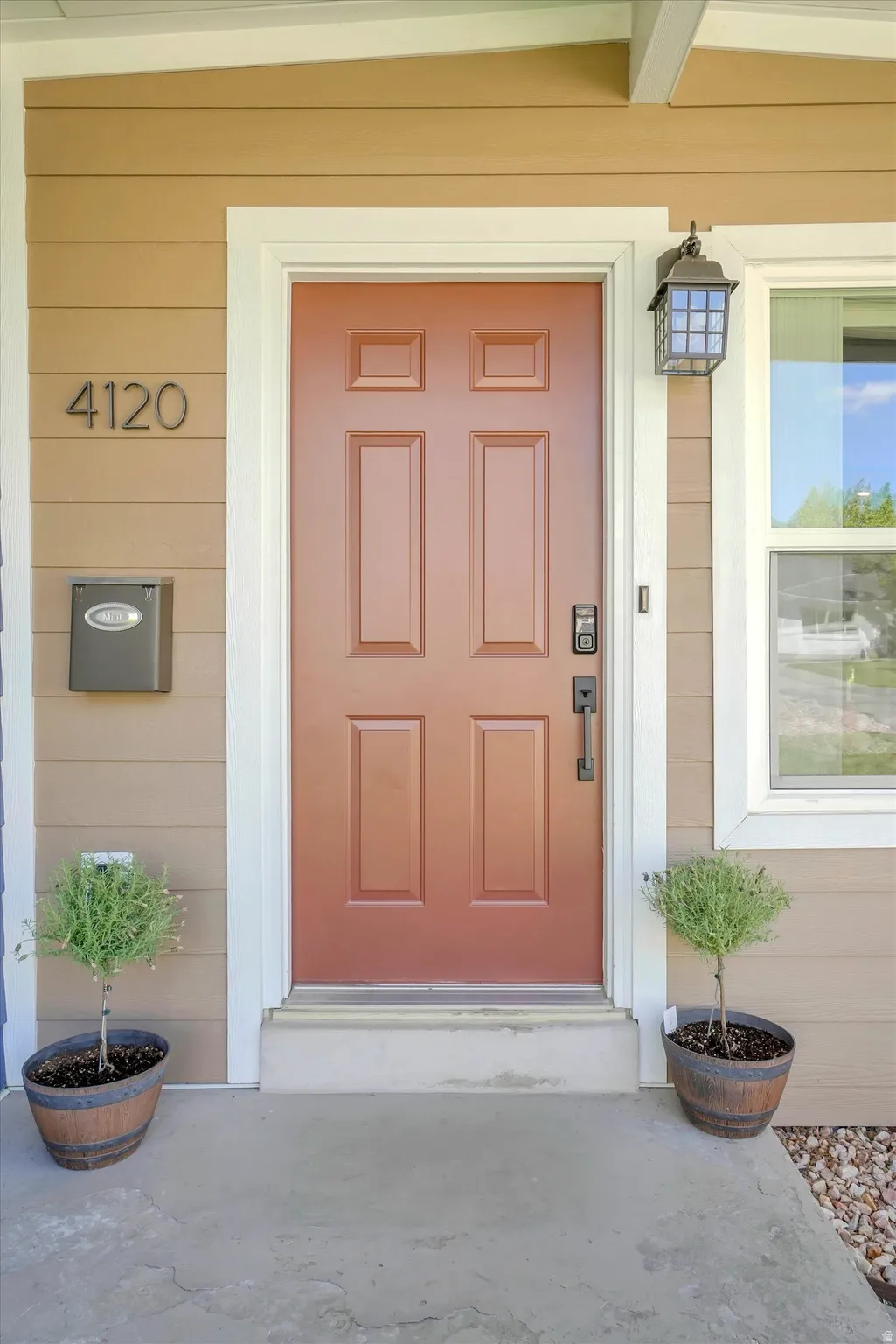 Entryway featuring a panel door with black hardware, exterior wall light, and horizontal siding