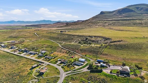 Expansive rural landscape featuring a mountainous backdrop and established residential development