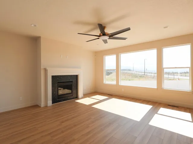 Open-concept living space with wood-finish flooring, a contemporary ceiling fan, and recessed lighting