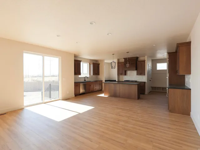 Open-concept living space with wood-finish flooring, recessed lighting, and sliding glass doors