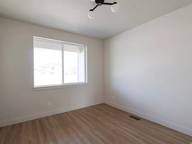 Wood-finish flooring, white walls, and a contemporary ceiling light fixture