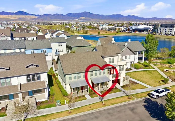 Modern townhome featuring a front porch, private balcony, and proximity to a large body of water