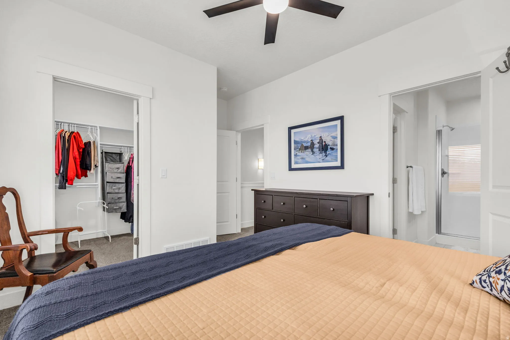 Bedroom space featuring a ceiling fan, light-toned walls, and wood-finish trim