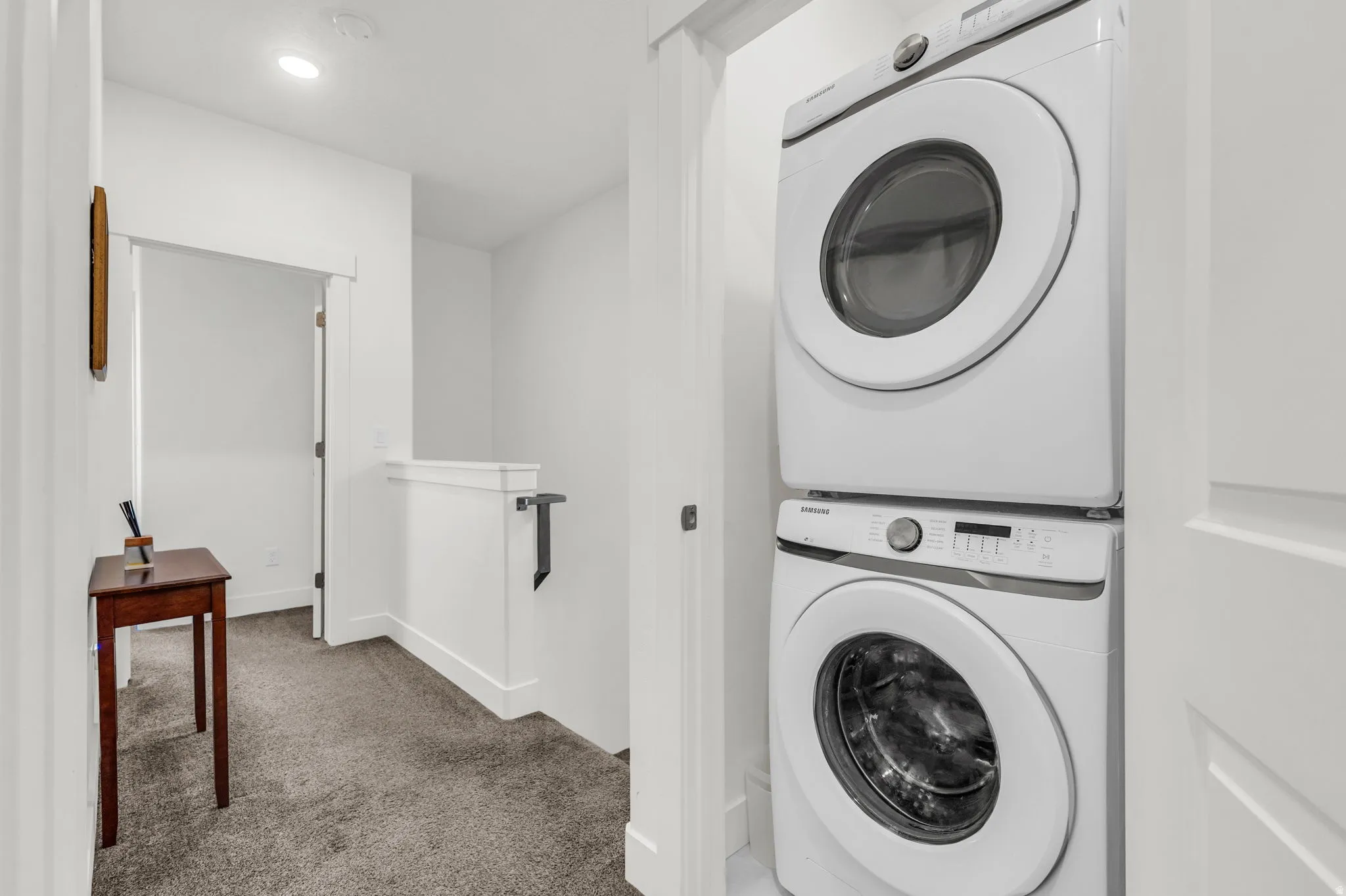 Dedicated laundry area featuring a stacked washer and dryer unit