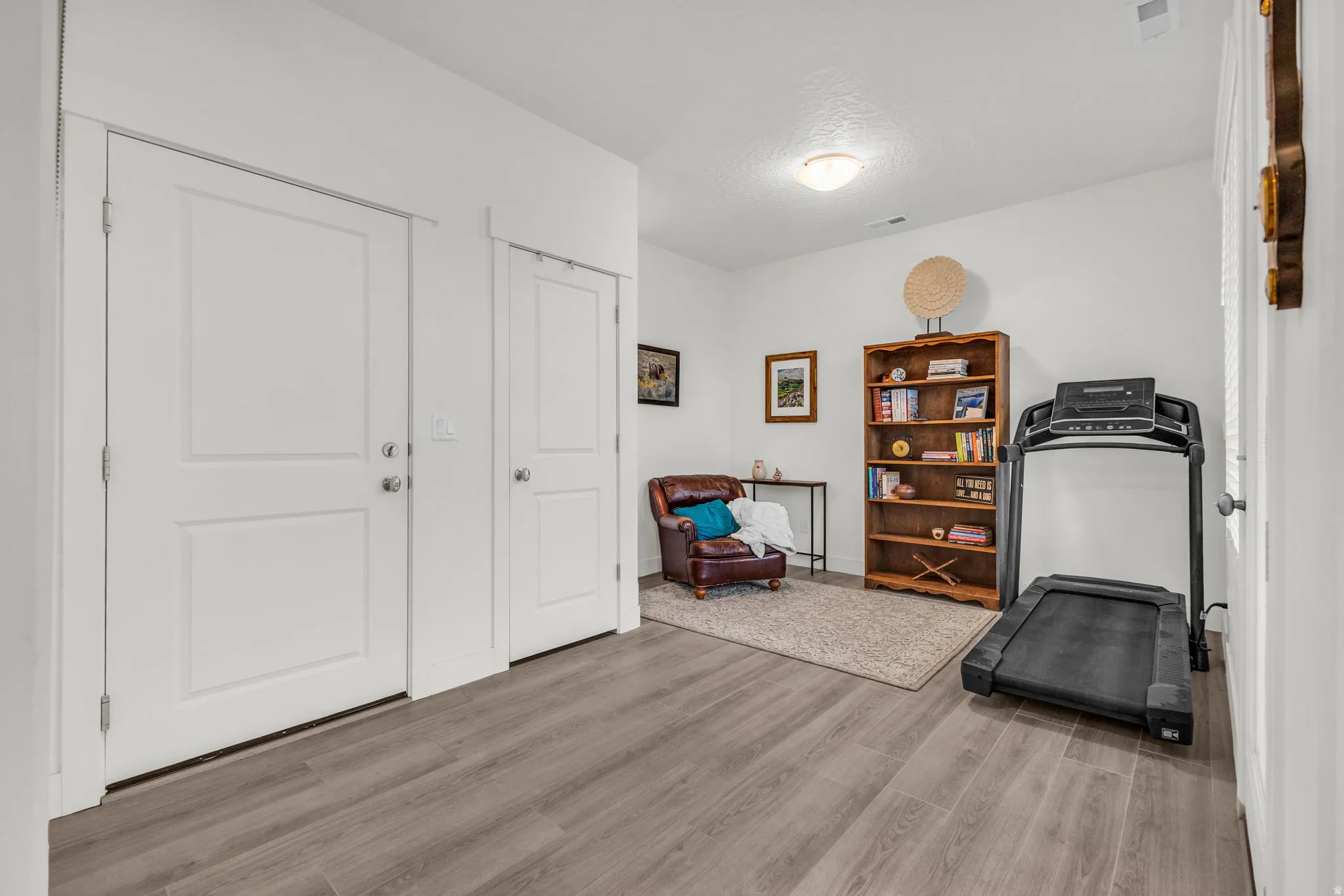 Spacious room off front door, perfect for an office or den.  Featuring wood-finish flooring, two panel doors with chrome hardware, and recessed ceiling lighting