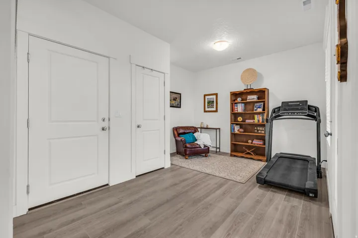 Spacious room off front door, perfect for an office or den.  Featuring wood-finish flooring, two panel doors with chrome hardware, and recessed ceiling lighting