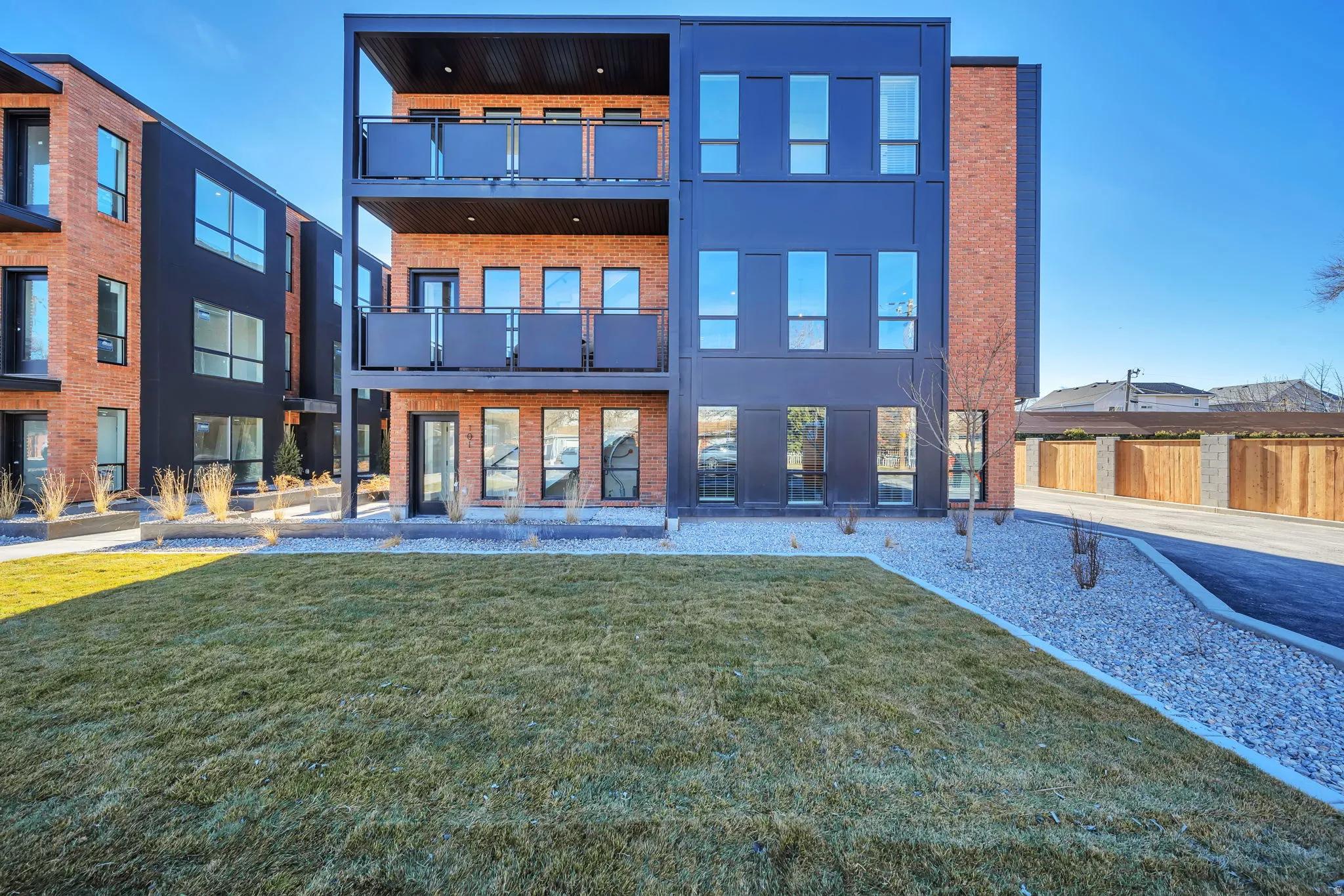 Contemporary multi-story building featuring a brick and dark panel facade