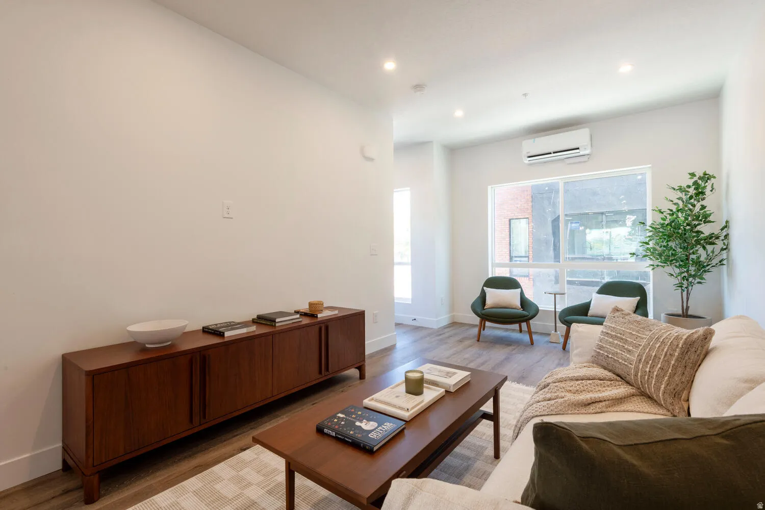 Open concept living area featuring light wood-finish flooring, recessed lighting, and large windows