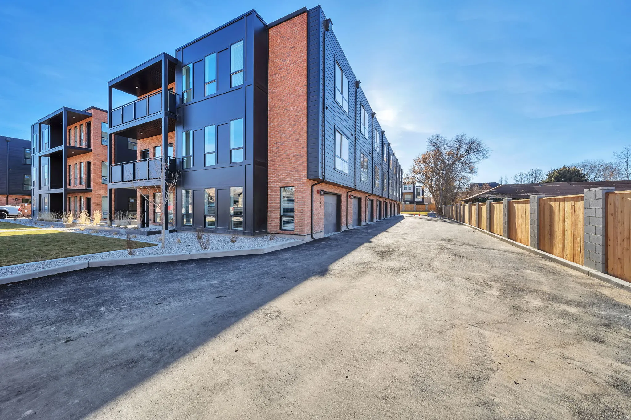 Contemporary multi-level building with brick and dark paneling facade