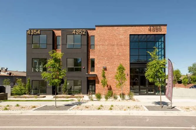 Contemporary multi-story building featuring a brick and dark-paneled exterior