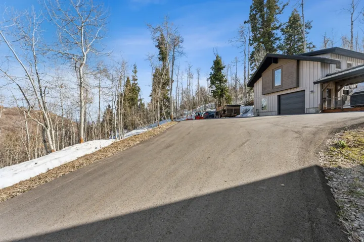 Asphalt driveway leading to a modern home with a two-car garage