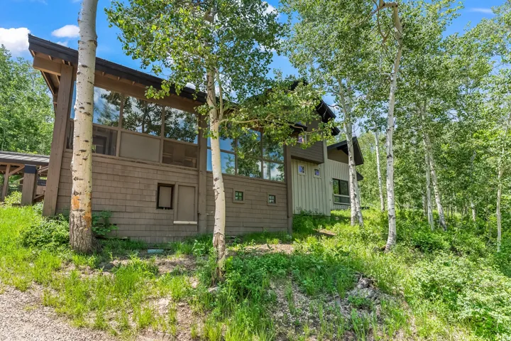 Contemporary exterior with expansive floor-to-ceiling windows, wood shake siding, and a sloped roofline