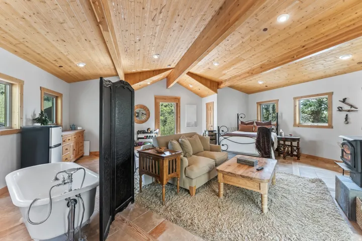 Vaulted wood-paneled ceilings with exposed beams, recessed lighting, and natural wood window trim
