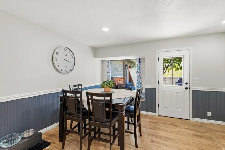 Dining area featuring wood-finish flooring, beadboard wainscoting, and recessed lighting