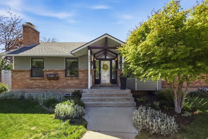 Split-level exterior featuring brick and horizontal siding