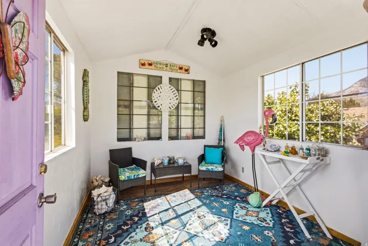 Bright sunroom with multiple windows and a purple entry door