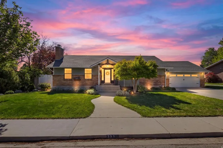 Ranch-style residence featuring a brick and siding exterior, an attached garage, and a concrete driveway