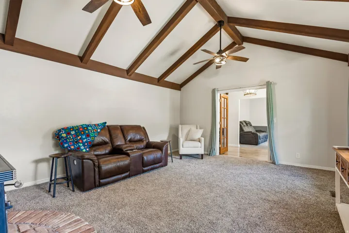 Vaulted ceiling with exposed wood beams and two ceiling fans