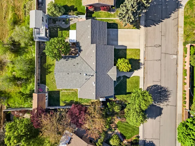 Aerial perspective showcasing a residential property with a dark shingle roof