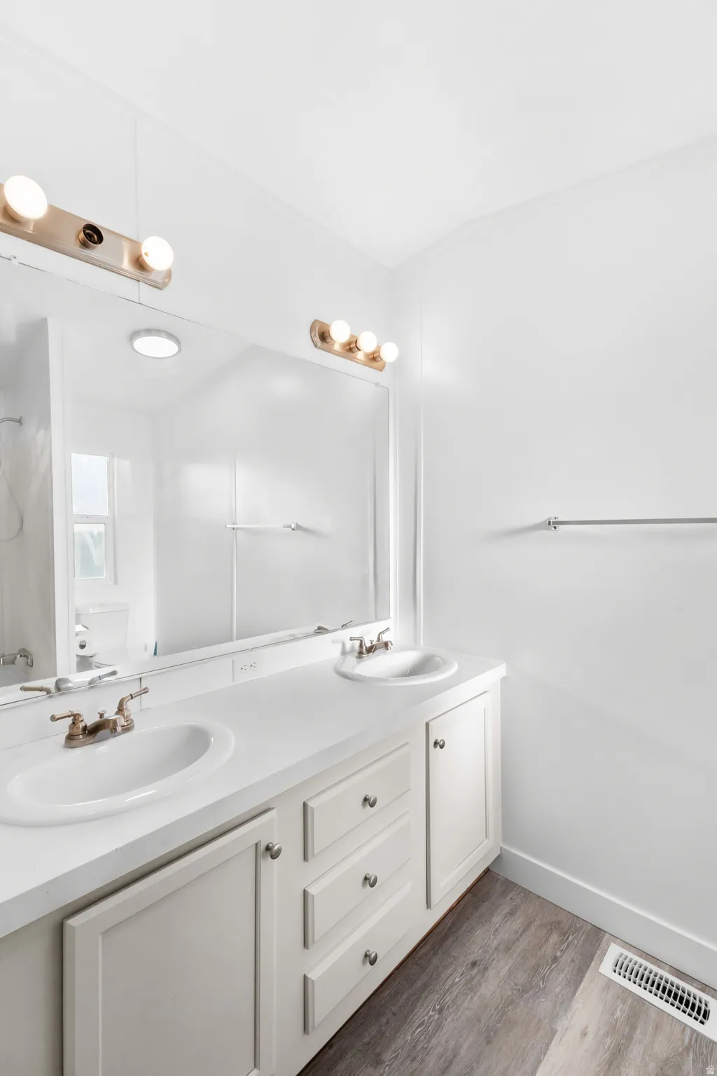 Double vanity featuring white cabinetry and integrated sinks with brushed nickel faucets