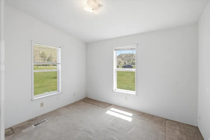 Neutral wall color with two windows and overhead flush-mount lighting