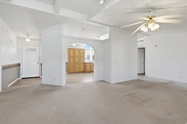 Central living area featuring light-toned carpeting and a ceiling fan with integrated lighting