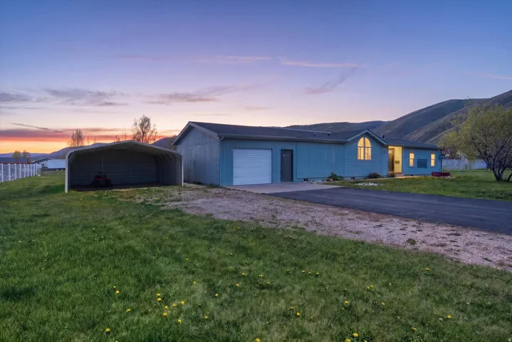 Ranch-style residence featuring a light blue exterior siding and a single-car garage with a white door