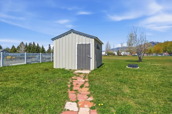 Freestanding storage shed with vertical siding and a dark gray door