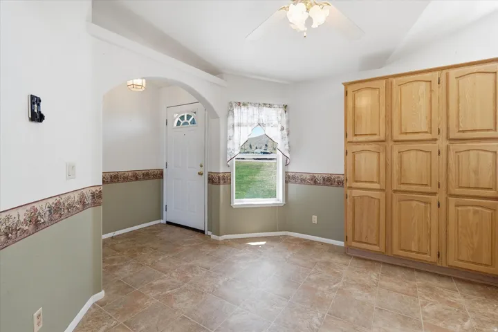 Spacious entryway featuring archway detailing, durable tile flooring, and integrated storage cabinetry