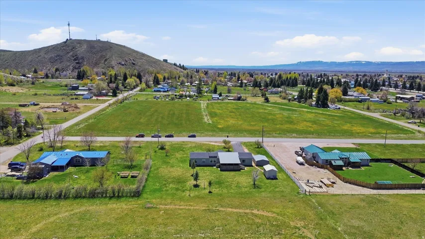 Expansive property featuring multiple structures, including a residence with a blue roof and a residence with a green roof