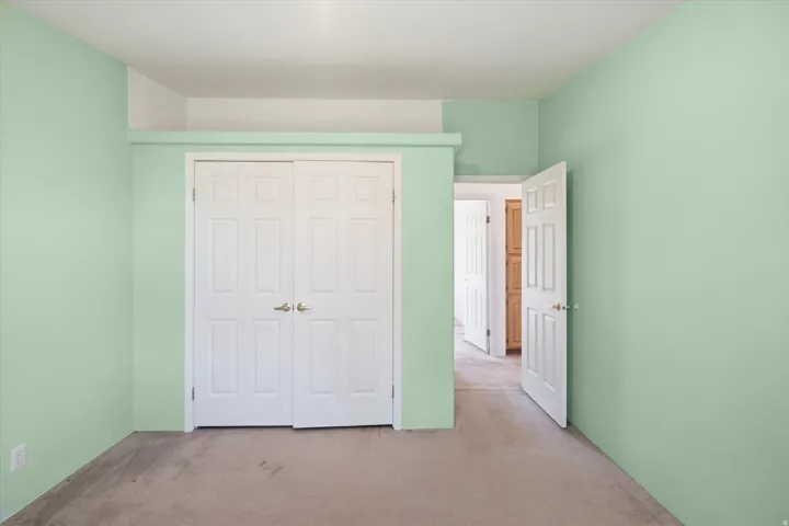 Wall-to-wall carpeting with light green painted walls