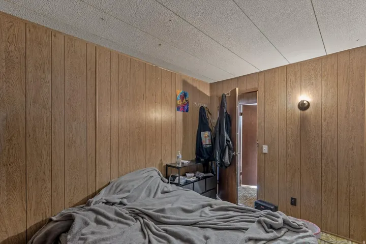 Interior room featuring wood-panel walls and a textured ceiling