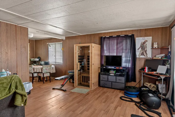 Spacious room with wood-finish flooring and wood paneling on the walls