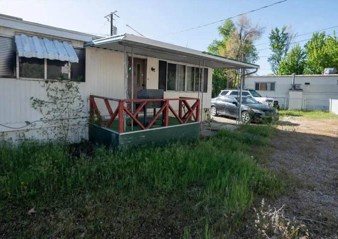 White siding exterior featuring a covered front porch with red railing