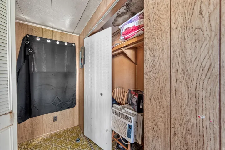 Room featuring wood-finish paneling walls and patterned floor covering