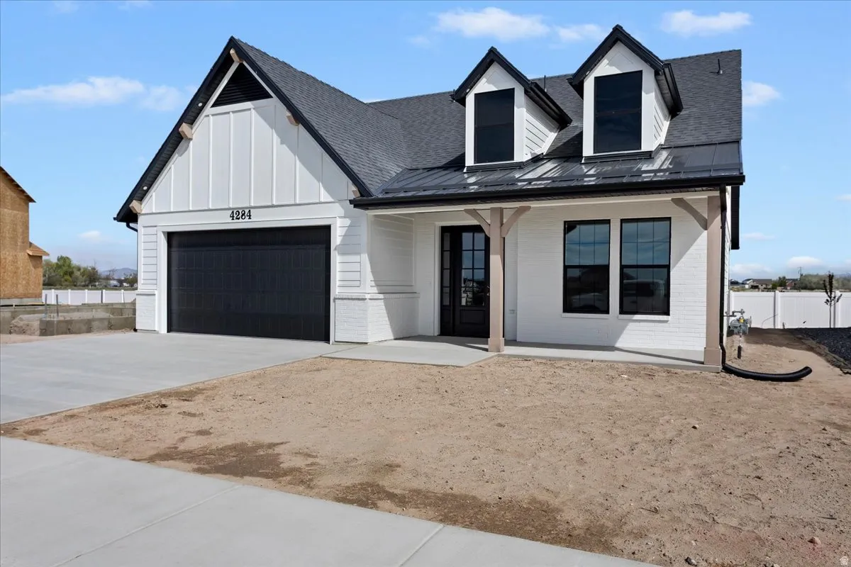 Modern farmhouse exterior featuring white brick and vertical siding