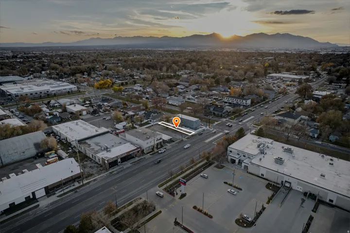 Commercial property with a multi-lane road frontage, paved parking area, and a flat roofline