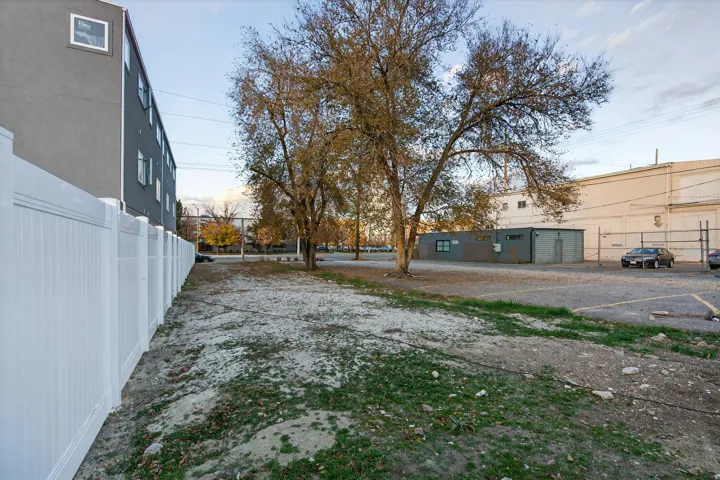 White privacy fence bordering a property with mature trees
