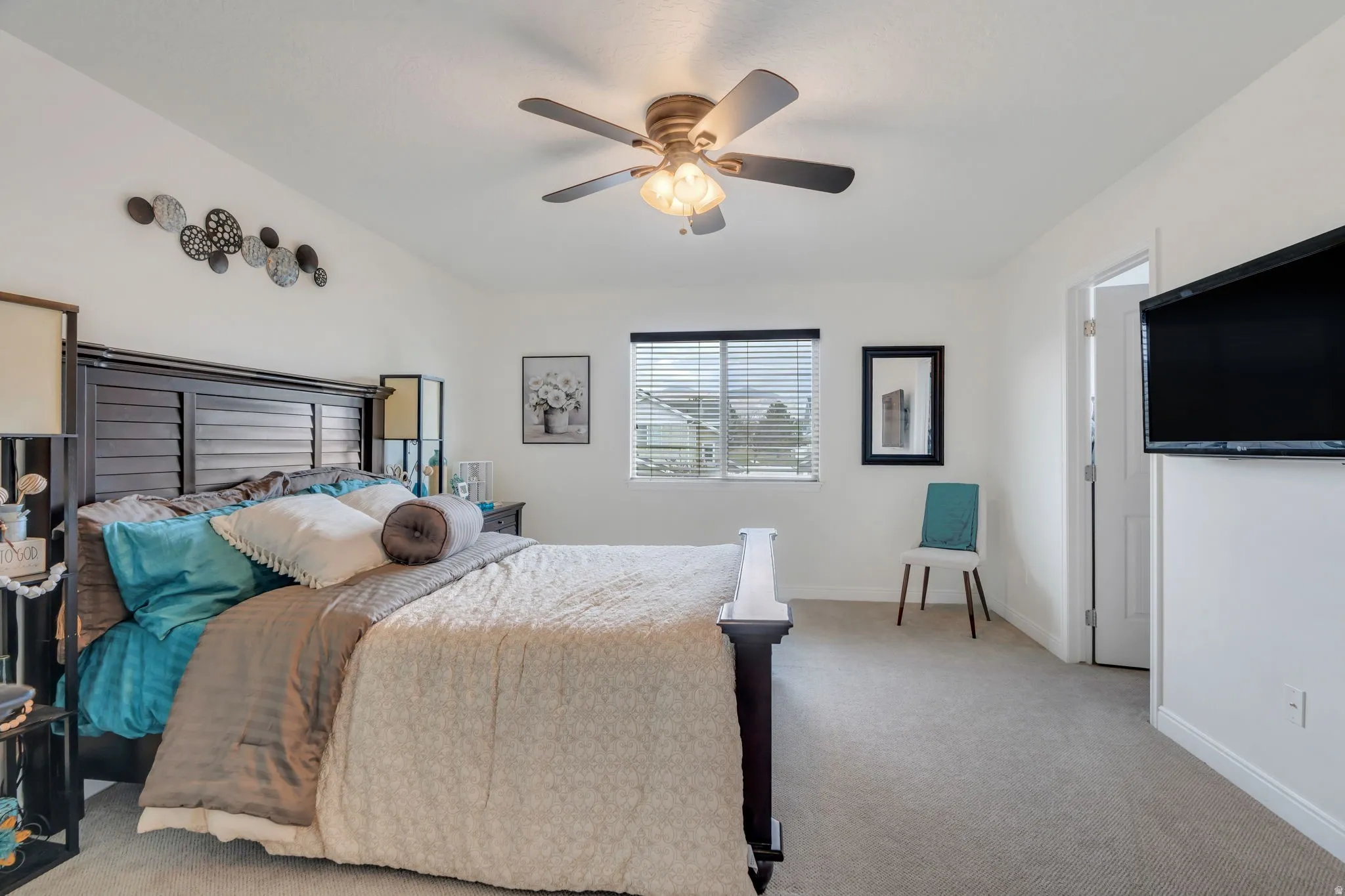 Spacious room featuring neutral carpeting, a large window with horizontal blinds, and a ceiling fan with integrated lighting