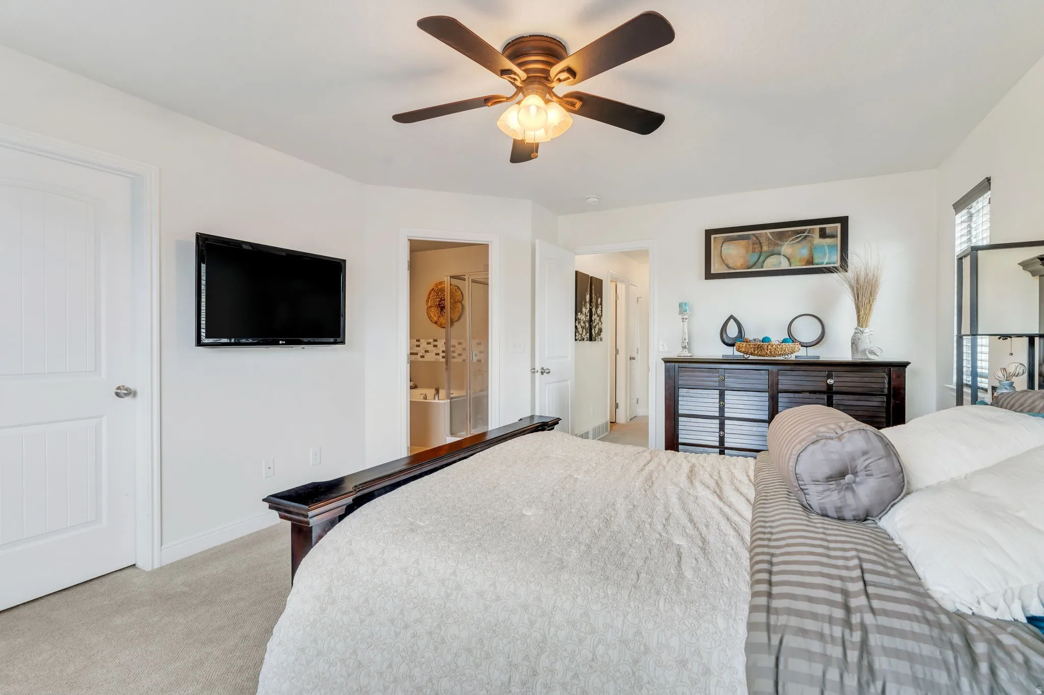 Bedroom featuring light-colored carpeting, a ceiling fan with integrated lighting, and white walls