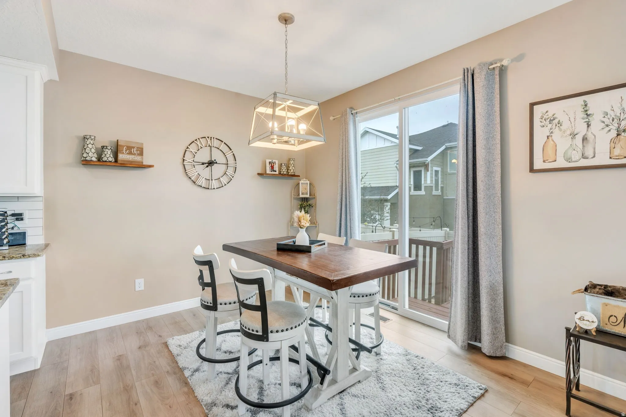 Dining area featuring wood-finish flooring, a white trim baseboard, and a sliding glass door leading to an outdoor deck