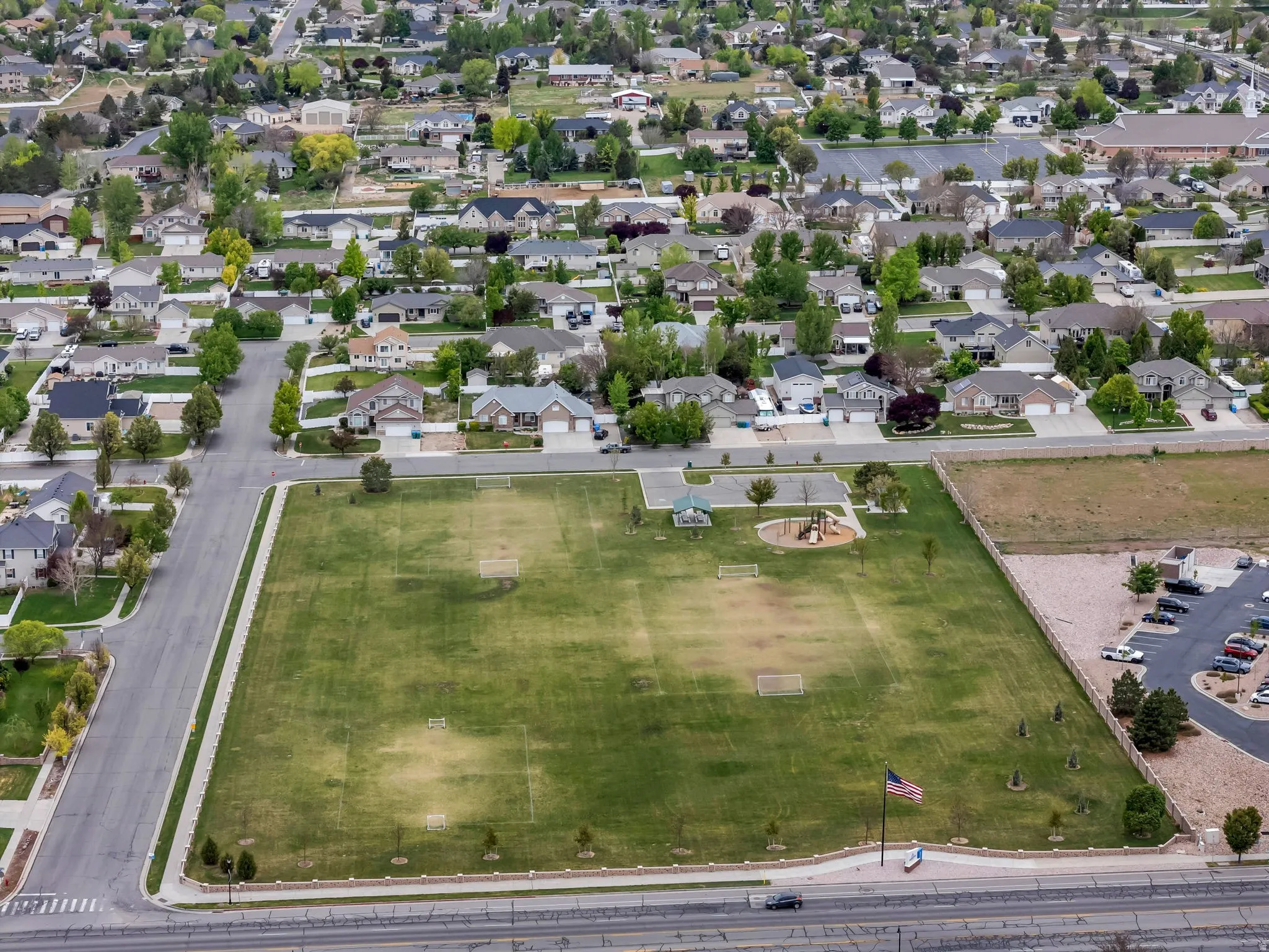 Expansive green space featuring a playground structure and covered picnic area
