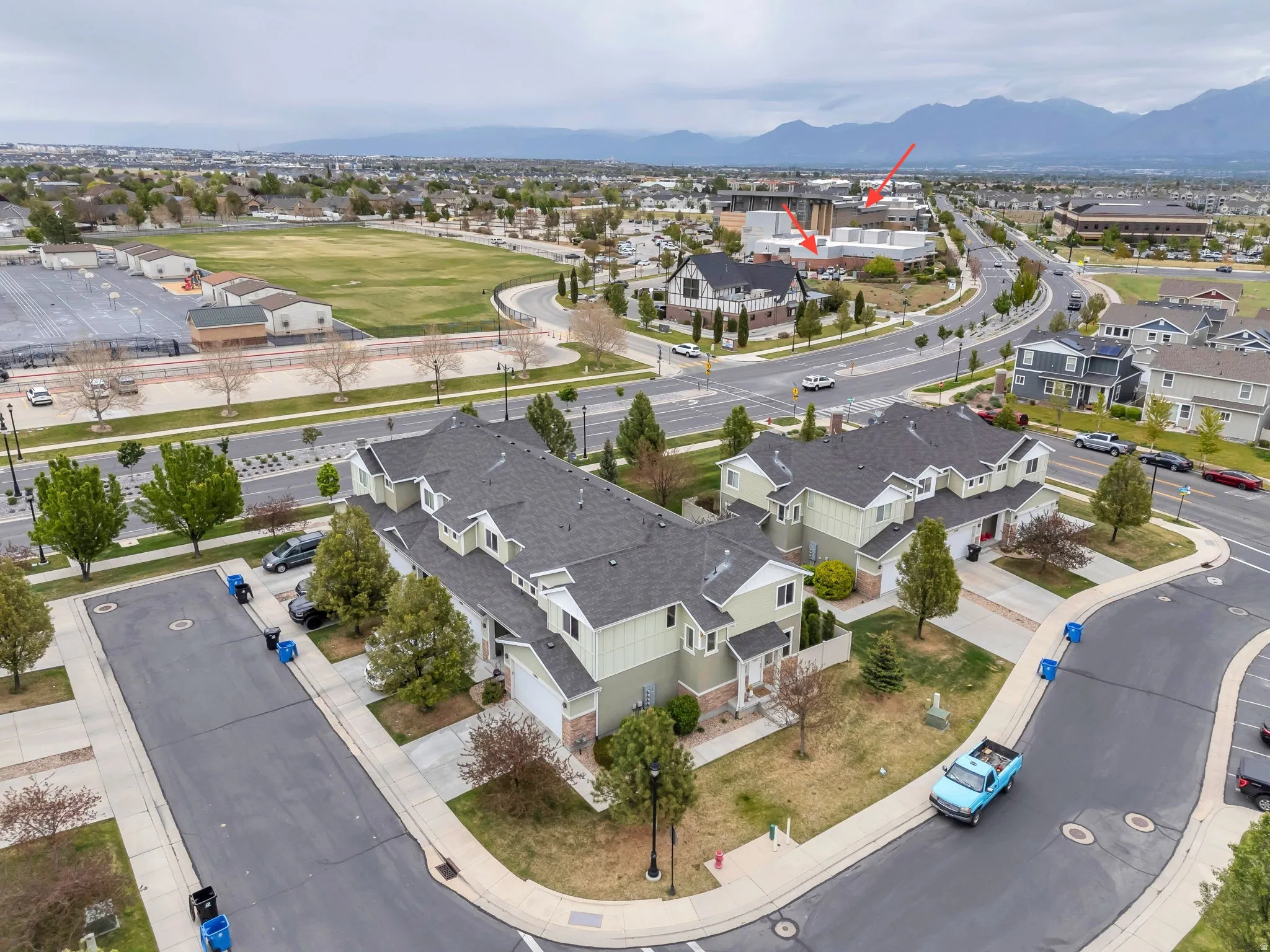 Residential complex featuring multi-story units with light green siding and dark shingle roofs