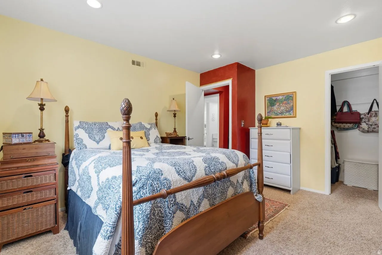 Primary Spacious bedroom featuring light-colored walls and soft carpet flooring with a walk in closet