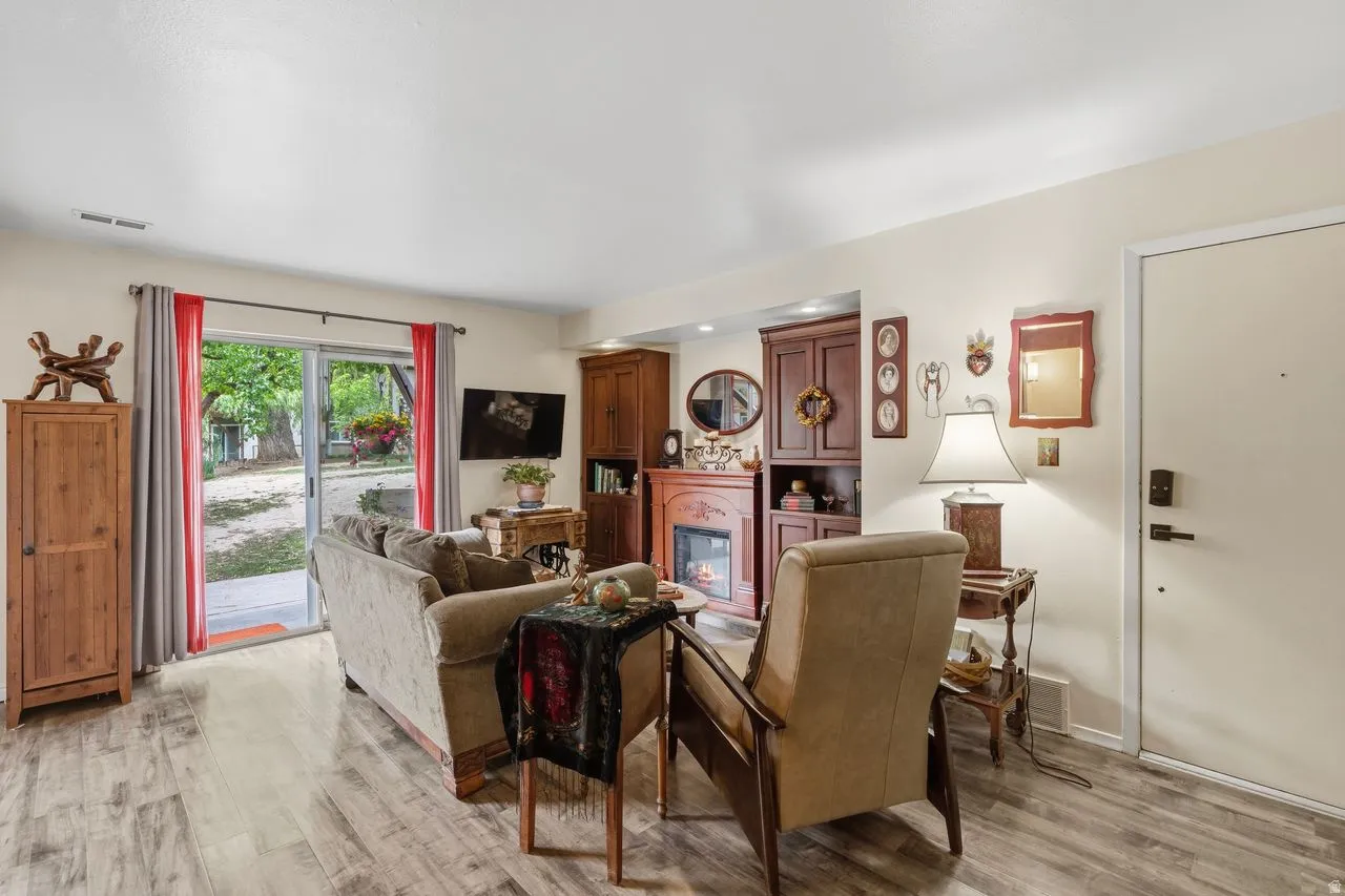 Living area featuring wood-finish flooring and a built-in entertainment center with a fireplace