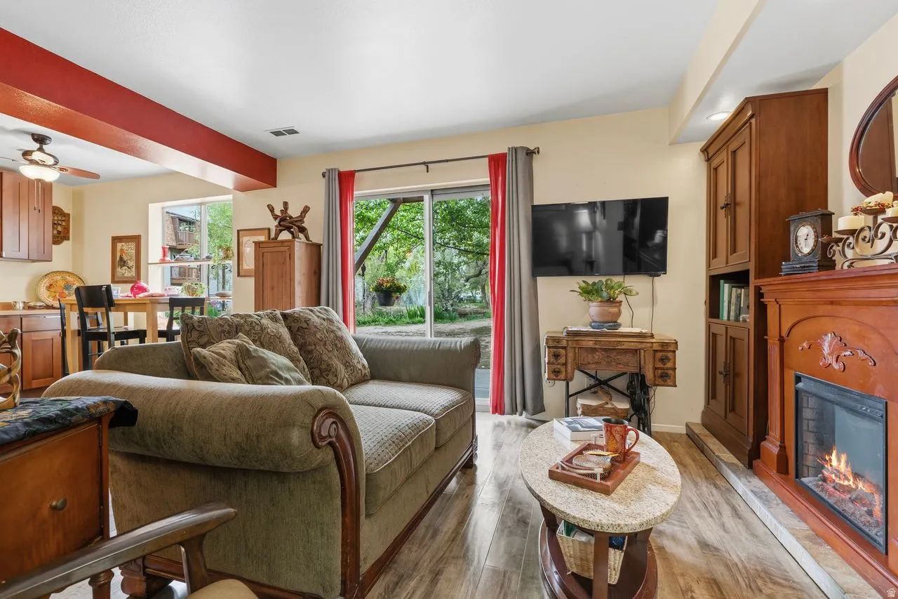 Living area featuring wood-finish flooring LVP, a free standing fireplace and a sliding glass door that leads to your little oasis