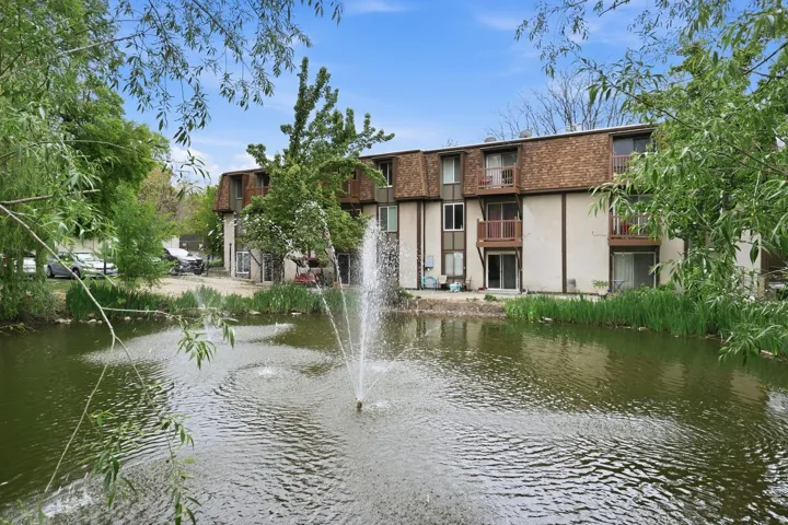 Water feature with multiple fountains, bordered by lush green foliage a Main Floor Two Bedroom Condo.